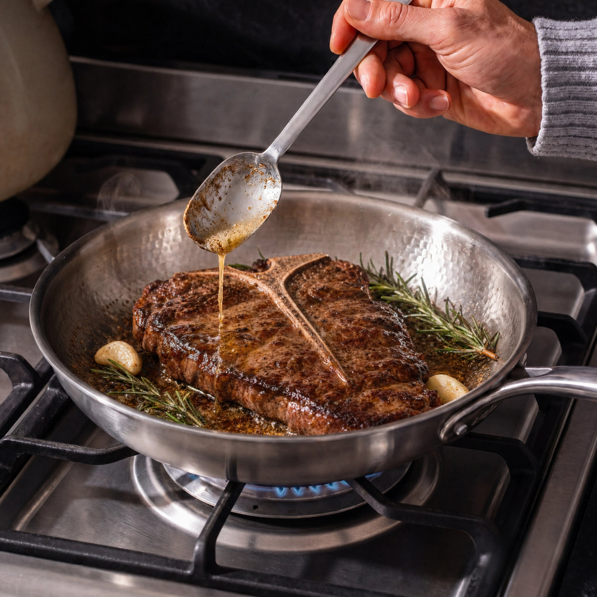 Steak mit Rosmarin und Knoblauch wird in der Titan-Pfanne mit Bratensaft übergossen